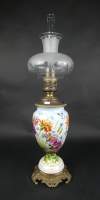 Objet : Lampe à pétrole en porcelaine décor peint monture en bronze globe en verre maté