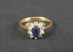 Bijou : Bague en or jaune 18K sertie d'un saphir ovale (usures) entouré de diamants