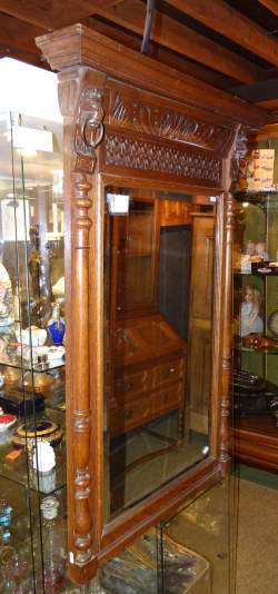 Meuble: Miroir en chene sculpté tete de lion demi-colonnes appliquées glace bise