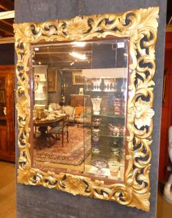Meuble : Important miroir biseauté de style à bordure en bois sculpté ajouré de rinceaux végétaux et rocailles